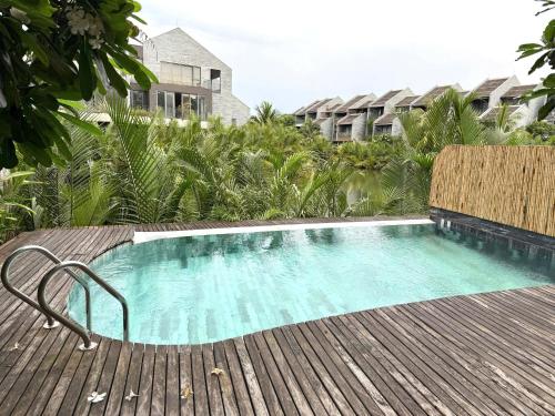 - une piscine installée à côté d'une terrasse en bois dans l'établissement Biệt Thự Hội An View, à Thanh Ðông (1)