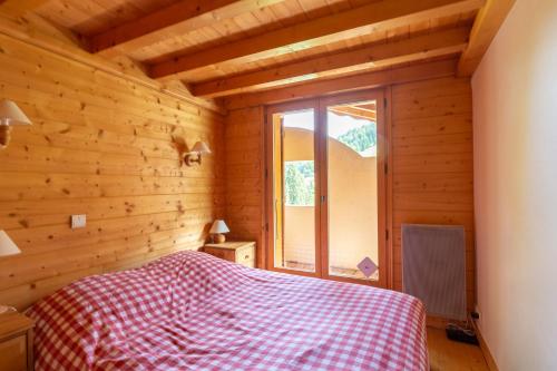 une chambre avec un lit dans une pièce en bois dans l'établissement CHARMANT CHALET près des pistes !, à La Clusaz