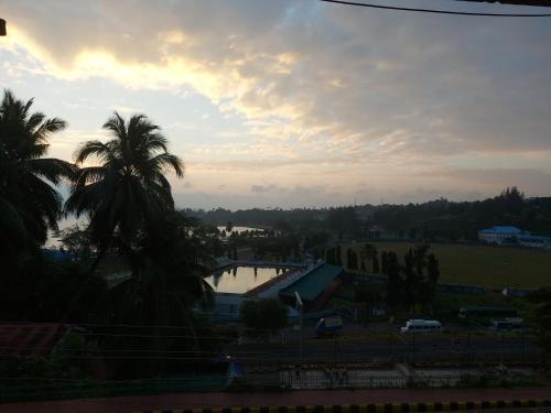 a view of a river with palm trees and a sunset at Hotel Amit in Port Blair