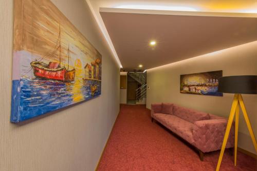 a living room with a couch and a painting on the wall at Yildiz Life Hotel in Trabzon