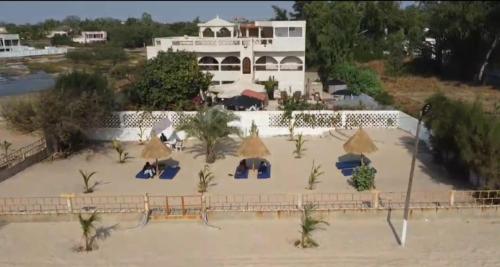 a building on the beach with chairs and umbrellas at Plage Blue Lagoon - Villa with Pool & Ocean Access in Warang