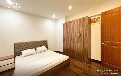 a bedroom with a bed and a wooden cabinet at Homestay Hạ Long NewLife in Kon Rung (1)