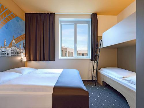 a bedroom with two bunk beds and a window at B&B Hotel Hannover-City in Hannover