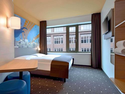 a hotel room with a bed and a large window at B&B Hotel Hannover-City in Hannover