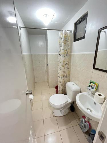 a bathroom with a toilet and a sink at RCL Homestay condo unit in Mactan Island