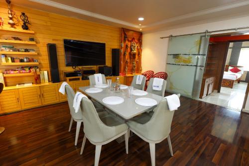 a dining room with a white table and chairs at SBHS Homestay - Neeladri - Mangalam Road in Tirupati