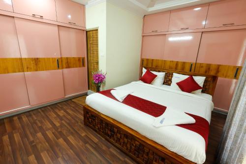 a bedroom with a large bed with red pillows at SBHS Homestay - Neeladri - Mangalam Road in Tirupati