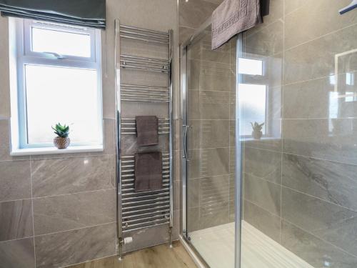 a shower with a glass door in a bathroom at Life's a Beach in Norwich