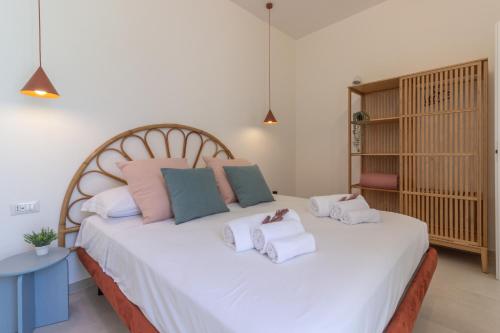 a bedroom with a large white bed with towels on it at mari DAMARI in Riposto