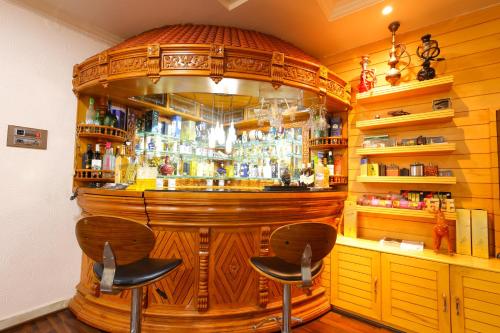 a wooden bar with two stools in front of it at SBHS Homestay - Neeladri - Mangalam Road in Tirupati