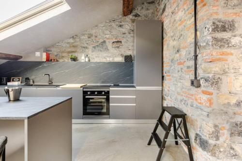 Una cocina con encimera y pared de ladrillo. en L'attico del Centro - Luxury Penthouse in Como Center, en Como