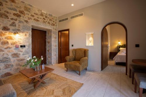 a living room with a chair and a table at Anemos Suites Mani 
