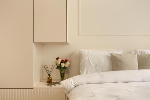 a white couch with a vase of flowers on a table at ARI Luxury Apartment with Balcony in Arad