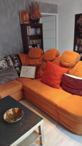 an orange couch in a living room with a table at Maison Peter 