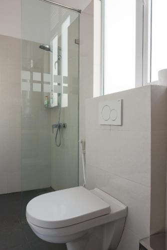 a bathroom with a toilet and a glass shower at The Den 23 in Maradana