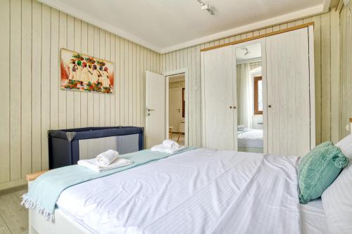 a bedroom with a large white bed with towels on it at Waterfront house with private dock by MN Property in Dobrota