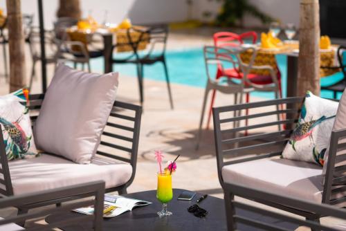 - une table avec deux chaises et une boisson dans l'établissement L'Adresse Dakar, à Dakar