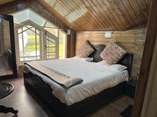 a bedroom with a bed in a room with a window at Lidder view The best River side Resort in Pahalgam in Pahalgām