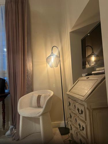 a room with a lamp and a chair and a dresser at Rossetti in Nice