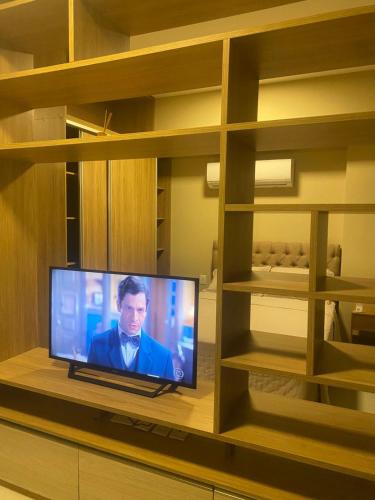 a television on a shelf in a room at Flat mobiliado, apto in Belém