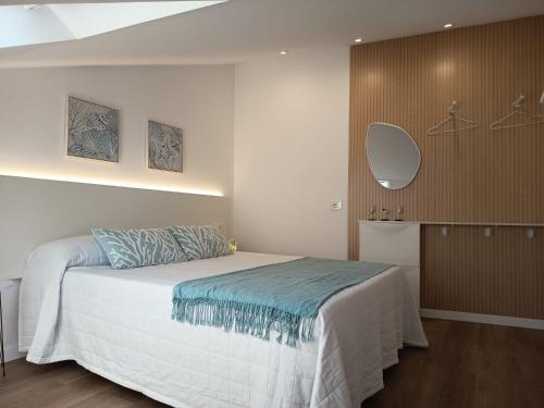 a bedroom with a bed with a blue blanket at Apartamentos turísticos Demar in O Grove