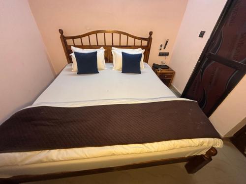 a bed with blue and white pillows on it at Hotel D7 in Jaipur