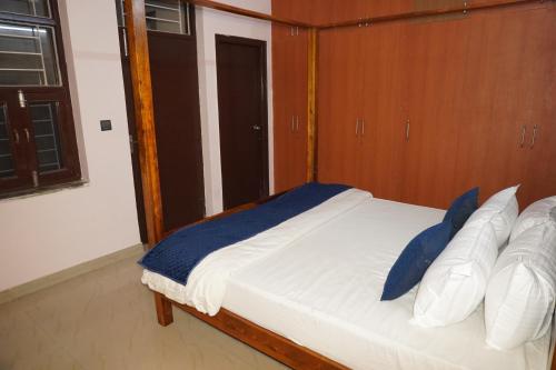 a bedroom with a bed with blue and white pillows at Hotel D7 in Jaipur