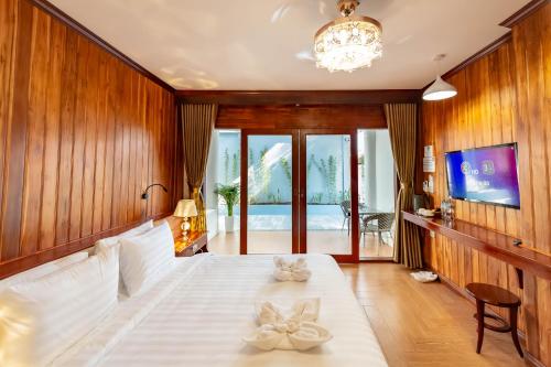 a bedroom with a large white bed with wooden walls at LUANGPRABANG CENTER Hotel in Luang Prabang
