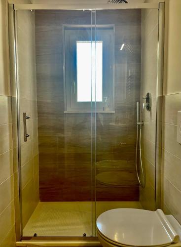 a bathroom with a shower with a toilet and a window at Sant'Angelo Country House in Trani