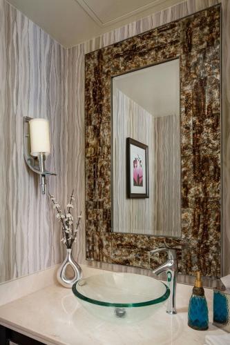 a bathroom with a glass sink and a mirror at The Woodlands Waterway Marriott Hotel and Convention Center in The Woodlands
