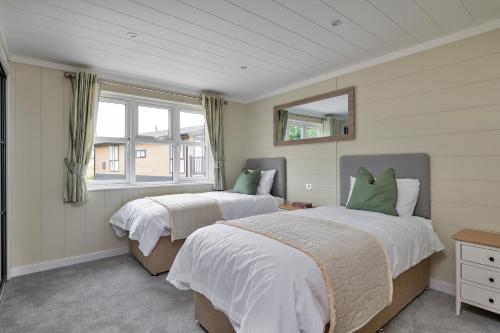 Un dormitorio con dos camas y una ventana. en Finest Retreats - Cambridge Luxury Lodge, 