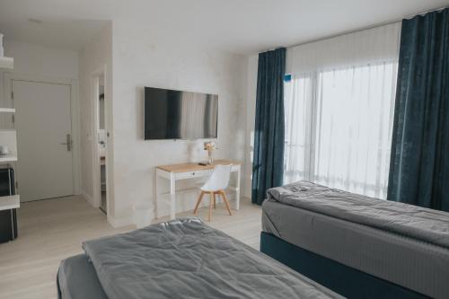 a bedroom with two beds and a desk and a television at WPO - WILD PIKE OASIS in Caraorman