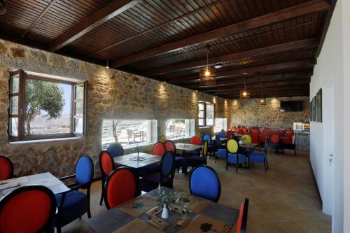 a restaurant with tables and chairs in a room at Anemos Suites Mani 