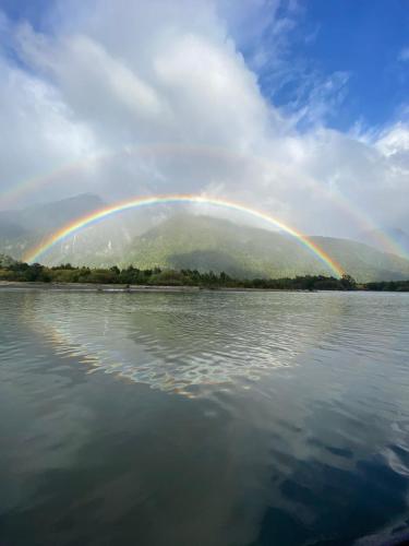 a rainbow over a large body of water at Cabañas El jardín de Jacinta in Coihaique