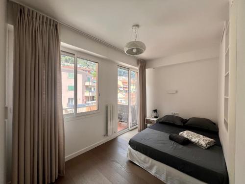 a bedroom with a bed and a large window at Sea-view Sunrise condo close beaches and Monaco in Cap d'Ail