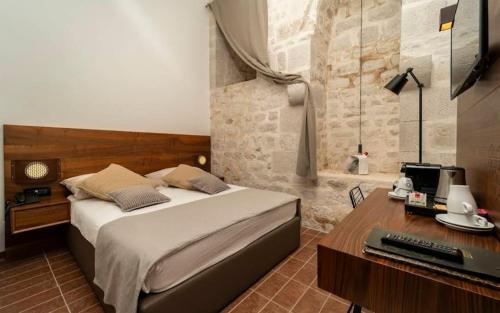 a bedroom with a bed and a desk with a computer at L10D10 Hotel in Baku