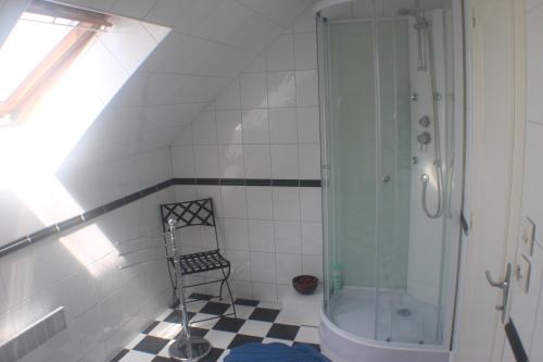 La salle de bains est pourvue d'une douche et d'une chaise. dans l'établissement Walnut House, à Vire