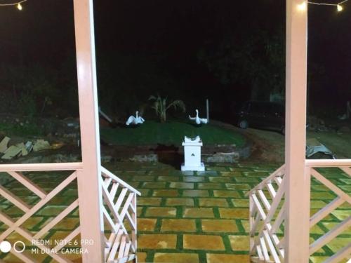 a white lighthouse in the middle of a yard at night at Holé's FarmVille in Mulshi