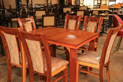 a wooden table and chairs in a restaurant at Lake Naivasha Lazarus Lodge in Naivasha