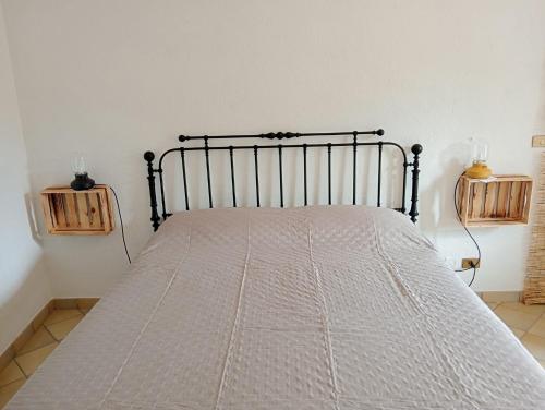 a bedroom with a bed with a white bedspread at La Casa del Ghiro in Brirus