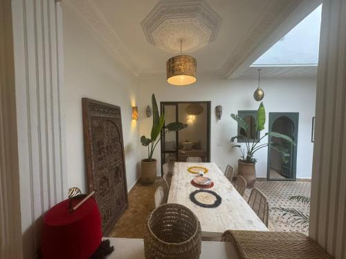 une salle à manger avec une table et des chaises en bois dans l'établissement Riad E&J Marrakech Médina 5 ch climatisées, piscine chauffée, EXCLUSIF, à Marrakech
