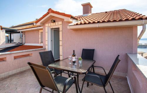 a patio with a table and chairs and a house at Apartman Nika in Omišalj