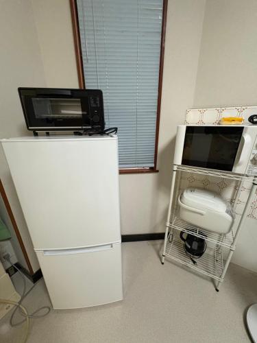 大津市にあるアパート一室堅田駅徒歩10分貸切可能の電子レンジが上に付いた白い冷蔵庫