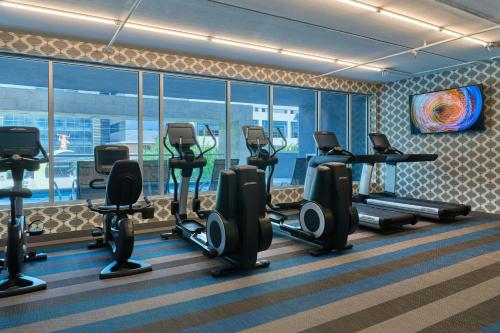 a gym with treadmills and elliptical machines at Aloft Richardson in Richardson