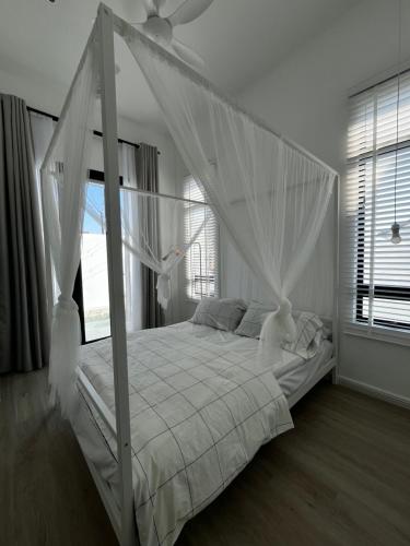 a bedroom with a white bed with a canopy at The Noice Villa Private pool in Kuantan