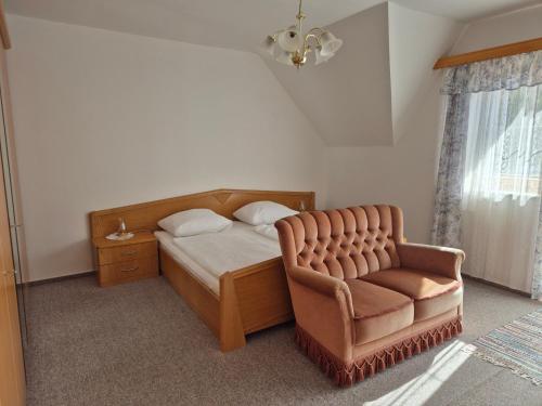 a bedroom with a bed and a chair at Bio-Bauernhof Wilfling in Miesenbach