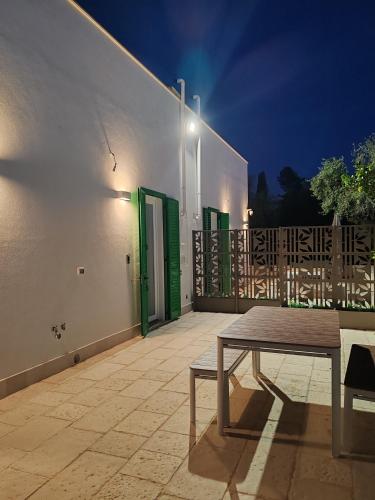 a patio with a table and a building at night at Domus de Palma in Molfetta