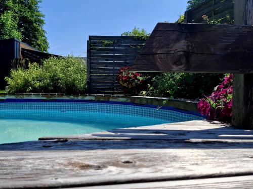 a wooden bench sitting next to a swimming pool at OSADA POD LASEM in Andrychów
