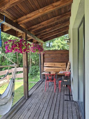 a deck with a table and chairs and flowers at OSADA POD LASEM in Andrychów
