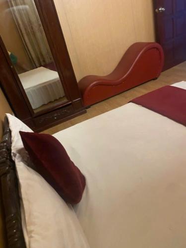 a bedroom with a bed with a mirror and a red chair at Thanh Lịch Homestay in Hanoi